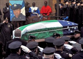 Mayor Bill de Blasio (second row, left, back to the camera) joins police at the funeral for an NYPD officer